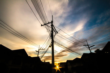 electric pole in village , silhouette style with sunset sky