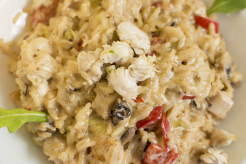Fragrant Pilau/Pulav / pilaf /pilaf, fried rice with meat and vegetables on a white plate. Isolated on a wooden table.