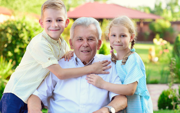 Portrait of happy old grandfather and cute children