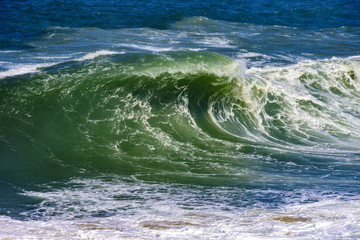 Fototapeta na wymiar Big, dangerous waves during tropical storm in the green and blue waters of Rio de Janeiro, Brazil
