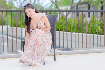 Portrait Beautiful woman asia posing on chair near the pool , Thailand