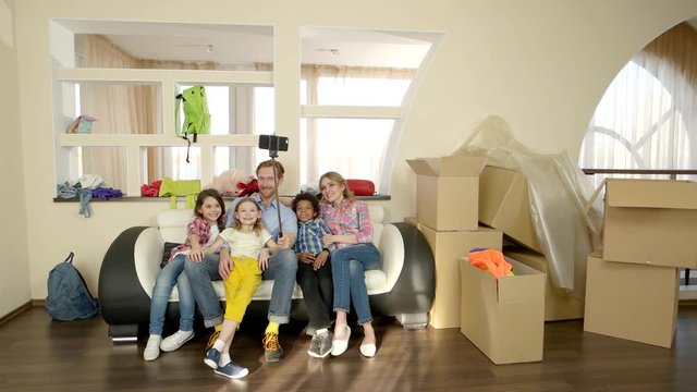 Family taking selfie indoors. Joyful people near cardboard boxes.