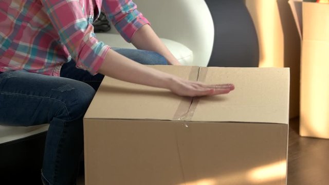 Woman packing cardboard box. Hands using adhesive tape. Best postal services.