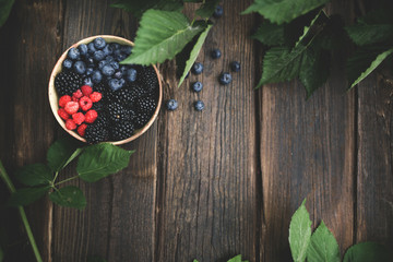 Bowl of fresh berries over beautiful old wood
