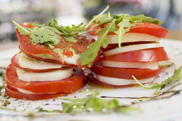 Fresh sandwiches with tomatoes, lettuce, cheese on a white plate.
