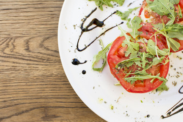 Fresh sandwiches with tomatoes, lettuce, cheese on a white plate.
