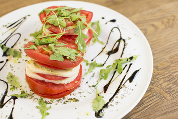Fresh sandwiches with tomatoes, lettuce, cheese on a white plate.