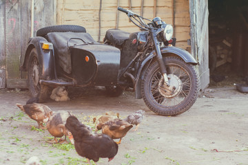 Old motorcycle with sidecar standing in a rural yard