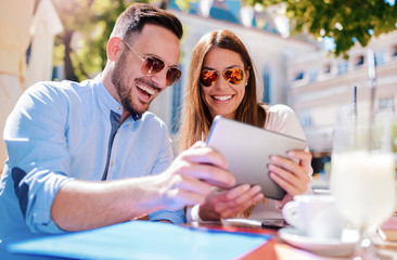 Young couple having fun with tablet. Dating, relationships, love, romance, lifestyle, technology