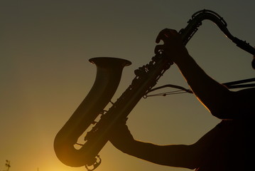 Fototapeta premium Saxophonist Playing At Sunset