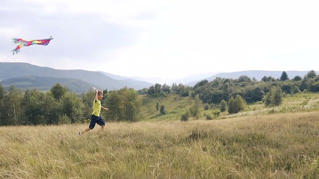 The boy runs and launches a snake in the mountains