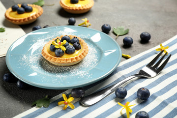 Delicious crispy tart with blueberries and custard cream on plate
