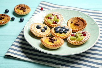 Obraz na płótnie Canvas Delicious crispy tarts with berries and custard cream on plate