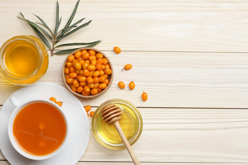 Sea buckthorn in wooden bowl, honey, Sea buckthorn juice on wooden table. top view with copy space