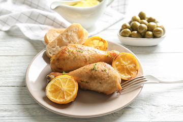 Delicious chicken legs with lemon on plate