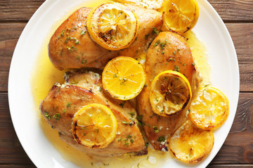 Delicious chicken breasts with lemon on plate, closeup