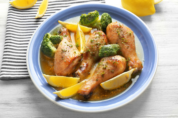 Delicious chicken legs with lemon on plate