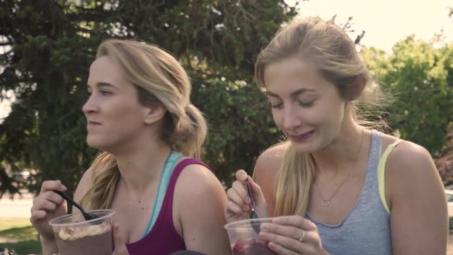 Closeup Of Happy Young Women Eating Healthy Acai Bowls For Breakfast Before Morning Workout, They Chat And Laugh