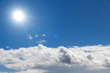 blauer Himmel mit Sonne und Wolken