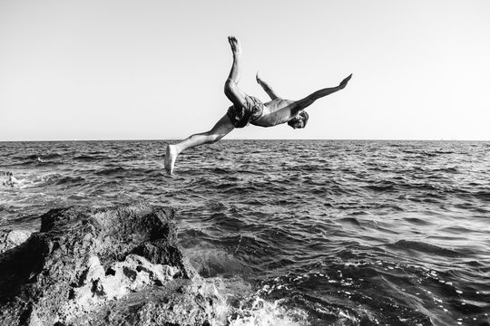 Young Man Jumping Into The Sea