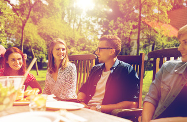 happy friends having dinner at summer garden party
