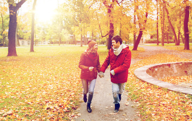 happy young couple running in autumn park