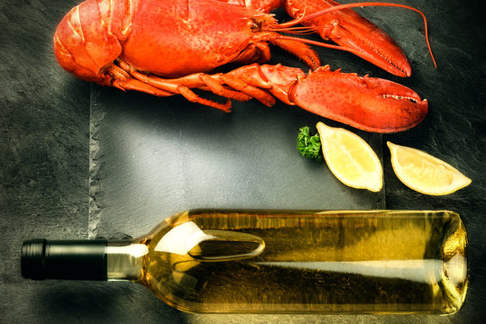 Fine selection of crustacean for dinner. Steamed lobster with bottle of white wine