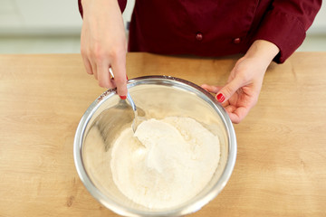 chef with flour in bowl making batter or dough