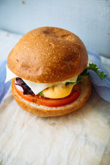 Tasty turkey burgers with corn salad and carrot,mixed seeds served on old board on a rustic wooden table with copyspace.