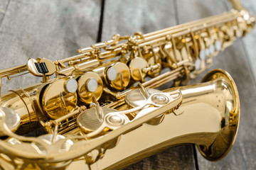 Obraz premium Beautiful golden saxophone on wooden background