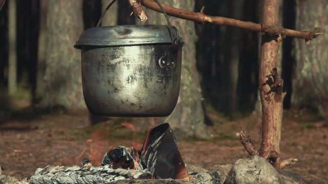 Kettle over campfire on sunny evening close-up