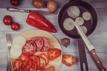 Eggs and chopped vegetables for rural eggs on rustic background