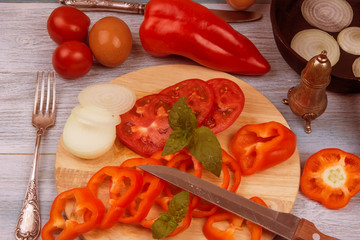 Eggs and chopped vegetables for rural eggs on rustic background