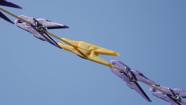 Plastic pegs against blue 3840X2160 UHD video - Close-up of yellow clothespin in row of purple sky 2160p 30fps UltraHD footage 