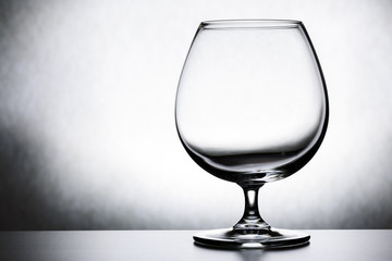 Single empty brandy glass on white background.