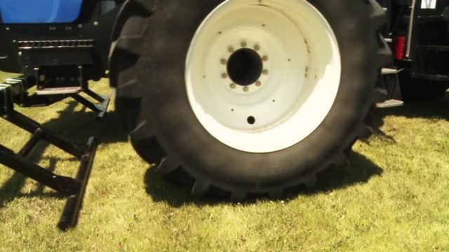 Close up, large tractor tires drive on field