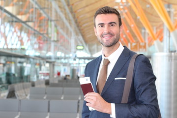 Elegant passenger holding passport and boarding pass at the airport 