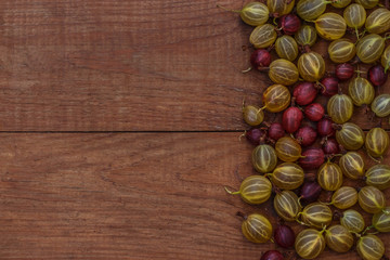 brown wooden background with green and red gooseberries