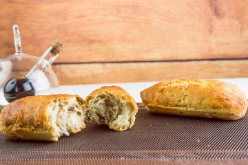 Fresh Backed Breads With Olives Next To Oil And Vinegar Bottle On Wooden Background