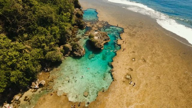 Tropical beach with natural rock pools in the Siargao Island. Aerial view Magpupungko natural rock pools. 4K, Travel concept, Aerial footage.