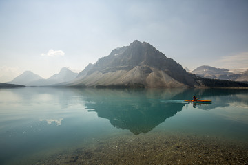 Obrazy na Szkle  jezioro polodowcowe z górami i kajakarzem