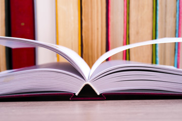 Open book, hardback books on bright colorful background.