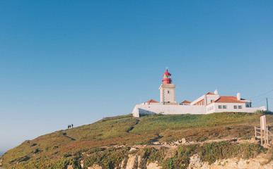 Fototapeta na wymiar The lighthouse in Cabo da Roca. Cliffs and rocks on the Atlantic ocean coast in Sintra in a beautiful summer day, Portugal