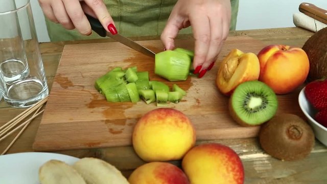 Woman with a knife regimen of a peach for fruit salad. Hd shot with dolly from left to right