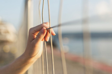 Woman's hand holding steel grating.