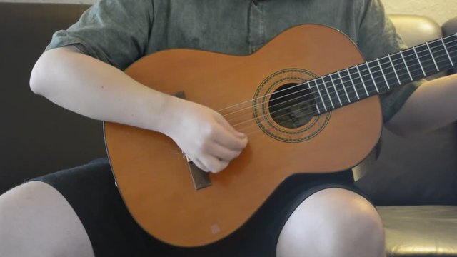 Junger Mann spielt akustische Gitarre