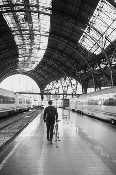 Young man with his bike walking away on the train platform