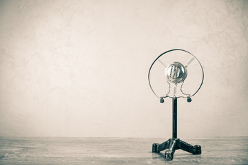 Retro microphone from 50s on wooden table. Vintage old style sepia photo