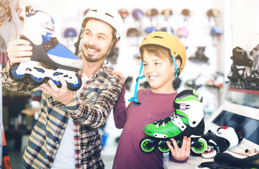 Fototapeta na wymiar father and son deciding on new roller-skates in sports store