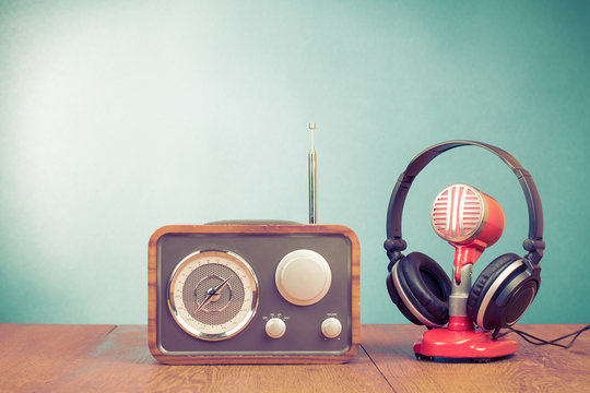 Retro radio, old microphone from 60s and old headphones front mint green background. Vintage instagram style filtered photo